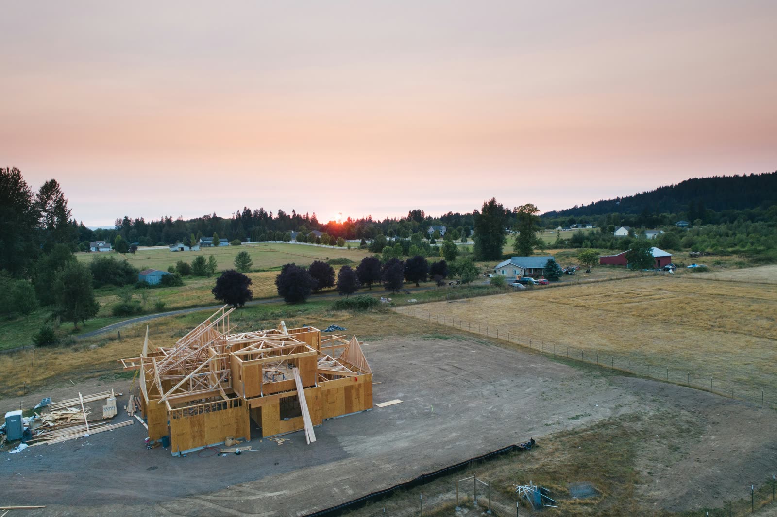 Aerial view of a new home build framed at sunset in a rural neighborhood